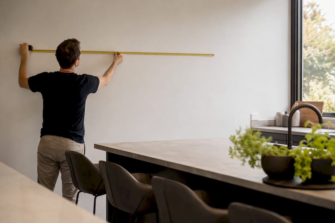 Hands measuring wall space for canvas