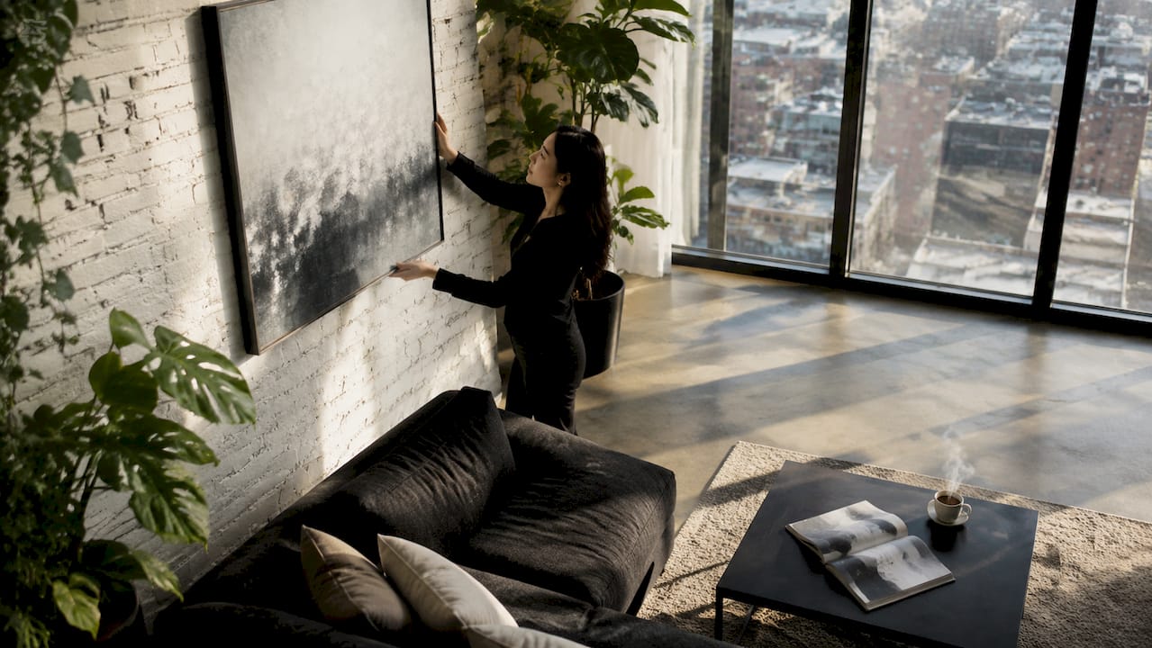Woman hanging canvas art in farmhouse living room